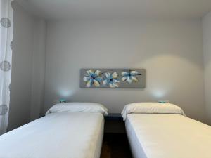 Dos camas en una habitación con un cuadro en la pared. en Yvacas 1B, en Tudela 29 fotos más