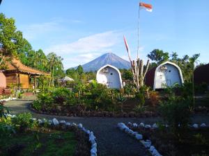 two domes in a garden with a mountain in the background at Indah Damai Cottages in Sidomukti