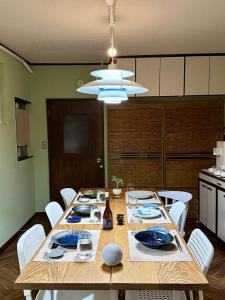 松本市にあるHosted Stay Minpaku Hallelujahの木製のテーブルと白い椅子のあるダイニングルーム