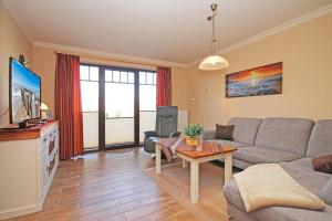 TV a/nebo společenská místnost v ubytování Urlaubstraeume-am-Meer-Wohnung-1-10-639