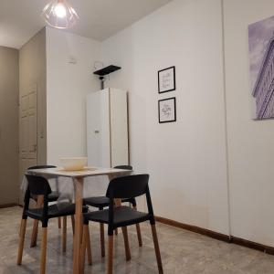 a table and chairs in a room with a refrigerator at Dpto Centeno Centrico 3 B in Santa Rosa +2 photos