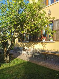una mesa y sillas bajo un árbol al lado de un edificio en Chalet céntrico costero en Gijón, en Gijón