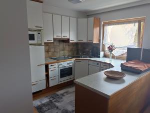 a kitchen with white cabinets and a counter top at Sepp's holiday apartment in Kapfenberg