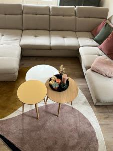 salon z dwoma stołami i kanapą w obiekcie Appart'Alencon w mieście Alençon +19 zdjęć