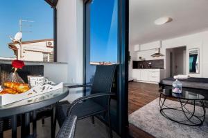 a living room with a table and chairs and a kitchen at Deluxe Apartments A&A - 2 in Rovinj