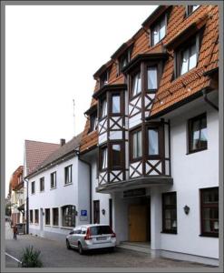 a car parked in front of a white building at Hotel Baeren in Leimen
