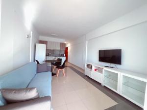 a living room with a blue couch and a flat screen tv at Ocean Breeze 1 Bedroom Apartment, Mirador Paraiso PP18 in Playa Paraiso