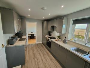a kitchen with gray cabinets and a large window at Hyecliffe House in Whitby