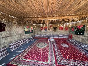 una stanza con un tappeto rosso sul pavimento di Authentic Nomads camp ad Al Wāşil