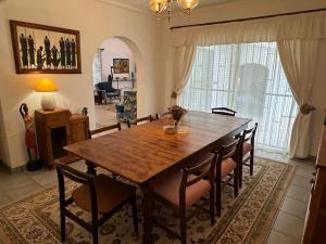 Un comedor con mesa y sillas de madera. en Private House with Pool, en Southbroom