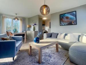 a living room with a couch and a table at Wiltsangh Bungalow in De Waal