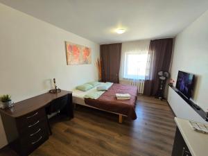 a bedroom with a desk and a bed in it at Z17 River apartment studio in Klaipėda