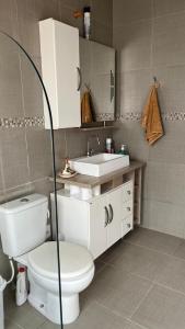 a bathroom with a toilet and a sink at Hospedagem Familiar in São Gabriel