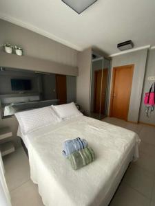 a bedroom with a white bed with a towel on it at Nautilus Concept - Penha/SC in Penha