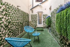 two blue chairs and a table in a courtyard at Sol Apartment III - En el centro de Madrid in Madrid