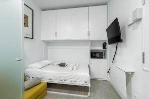 a white room with a bed and a television at Sol Apartment III - En el centro de Madrid in Madrid