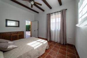 ein Schlafzimmer mit einem Bett und einem Deckenventilator in der Unterkunft Casa el Rincón del Lago Alojamiento Rural in Córdoba + 37 Fotos