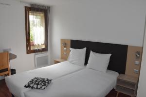 Postelja oz. postelje v sobi nastanitve Hôtel Bagatelle Paris Nord Roissy CDG