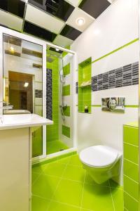 a green and white bathroom with a toilet and a shower at Nikolaos Apartment by Flat Mаnager in Plovdiv