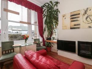 a living room with a red couch and a television at 9 Old City Chambers in Bristol