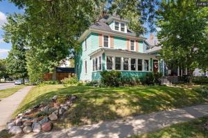 una casa verde con un cortile con rocce di Hot Tub King Beds Near Grand Avenue a Saint Paul