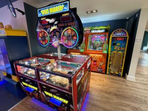 a room with several arcade games and a pinball machine at Puddleducks, Dog Friendly Hot Tub Lodge in South Cerney
