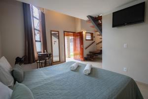 a bedroom with a bed with two towels on it at Pousada Nefelibatas in Águas de Lindoia +79 photos