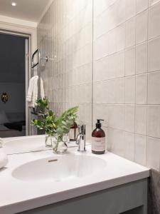 La salle de bains est pourvue d'un lavabo et d'un vase de fleurs. dans l'établissement Bergvillan Ski Lodge, à Åre