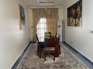 a dining room with a table and chairs and a window at Your Luxury Home away from Home in Gwarinpa +14 photos