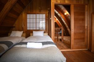 two beds in a room with an attic at The Cabin in Hakuba
