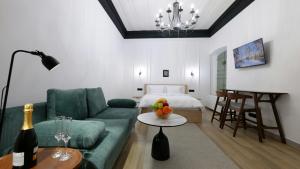 a living room with a green couch and a bed at Tango Guest House in Gyumri