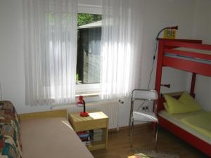 a bedroom with a bed and a chair and a window at Huus Westerdiek in Dornum