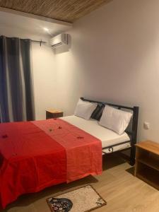 a bedroom with a bed with a red blanket at Résidence Kanissa in Cap Skirring