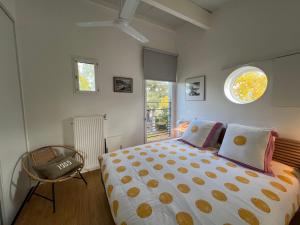 a bedroom with a bed and a chair and a window at La Maison de Jane Château&Beauval in Cormeray +11 photos