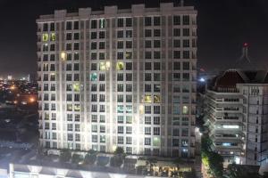 a large white building with many windows at night at The Square - King Suite - Apartemen Service - 2Person - NetFlix Wifi - Near Petra Campus in Surabaya