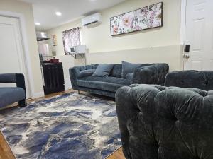 a living room with two couches and a rug at West Babylon Bliss in West Babylon