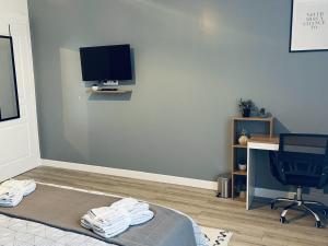 Una televisión o centro de entretenimiento en Au Logis Briand - Appartement 3 Chambres - Bâtiment historique 29 fotos más