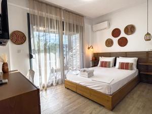 a bedroom with a bed and a large window at Bamboo Luxury Studios in Nikiti