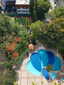 una vista sul tetto di due piscine con alberi di Waterfront High Tide Suite - Ocean View a Ban Karon