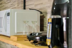 eine Küchentheke mit Kaffeemaschine und Mikrowelle in der Unterkunft Pousada kanoas suites in São José da Coroa Grande + 28 Fotos