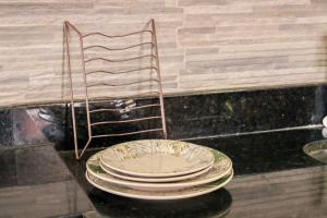 einem Stapel Teller auf einem Tisch mit einem Stuhl in der Unterkunft Pousada kanoas suites in São José da Coroa Grande