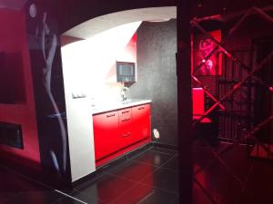 a red kitchen with a red cabinet in a room at Apartament Grey in Tuchola