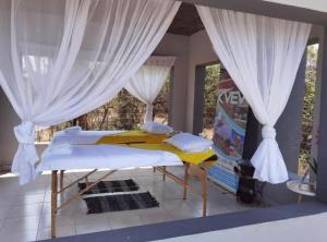 a bed in a room with white curtains at Kings view exclusive villas in Petronella