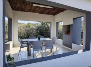 a dining room with a table and chairs on a patio at Kings view exclusive villas in Petronella