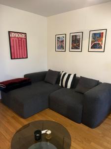 a living room with a blue couch and a glass table at Appartement Paisible au Vert in Saint-Ouen