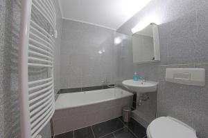 een badkamer met een bad, een wastafel en een toilet bij Apartment 238 in Hohegeiß