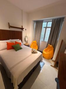 a bedroom with a large bed with orange and green pillows at Studio Moderno in Botafogo in Rio de Janeiro +16 photos