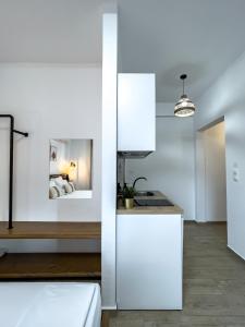 a white kitchen with a sink and a counter at Bamboo Luxury Studios in Nikiti