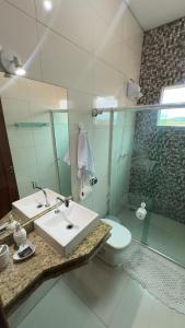 a bathroom with a sink and a toilet and a mirror at Casa para temporada in Guapé