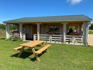 a wooden picnic table in front of a house at Ferienhaus an der Ostsee in Vaisi